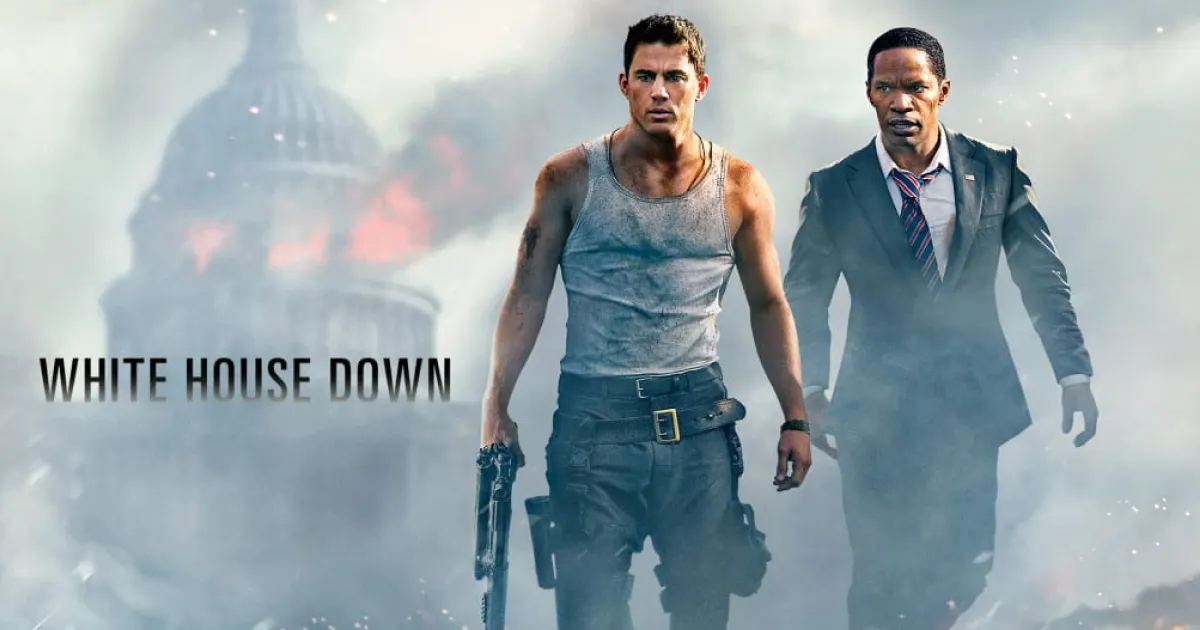 The movie poster for white house down - shows two men walking away from a burning white house. 
