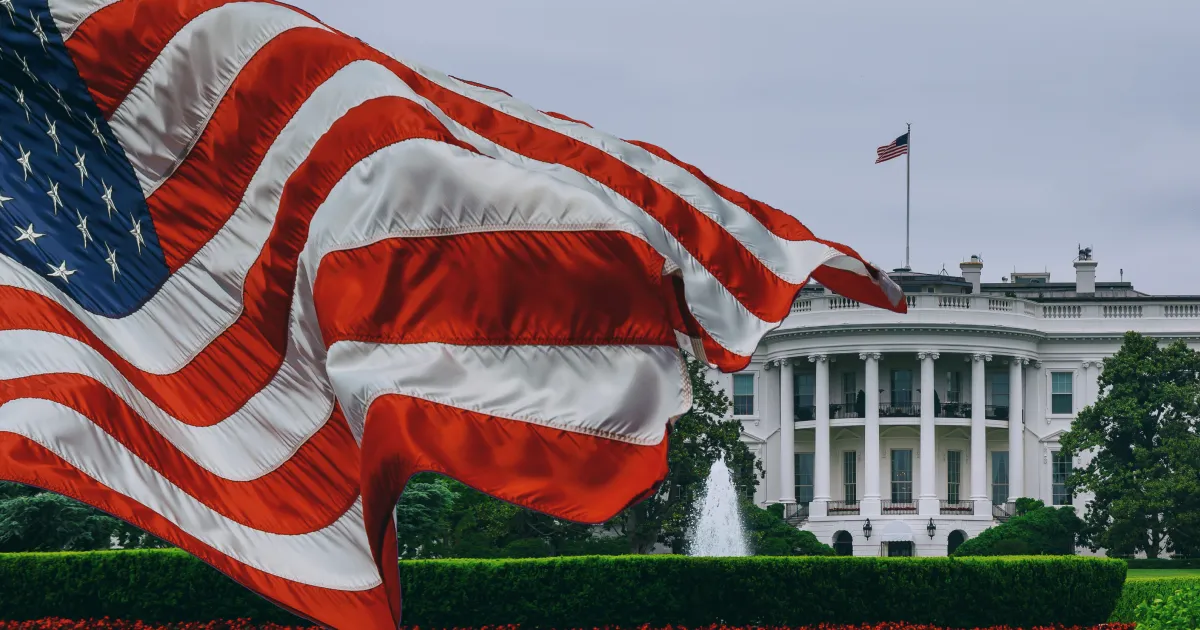 Header image for the blog white house announces plan for supply chain resilience showing a picture of the white house with an american flag