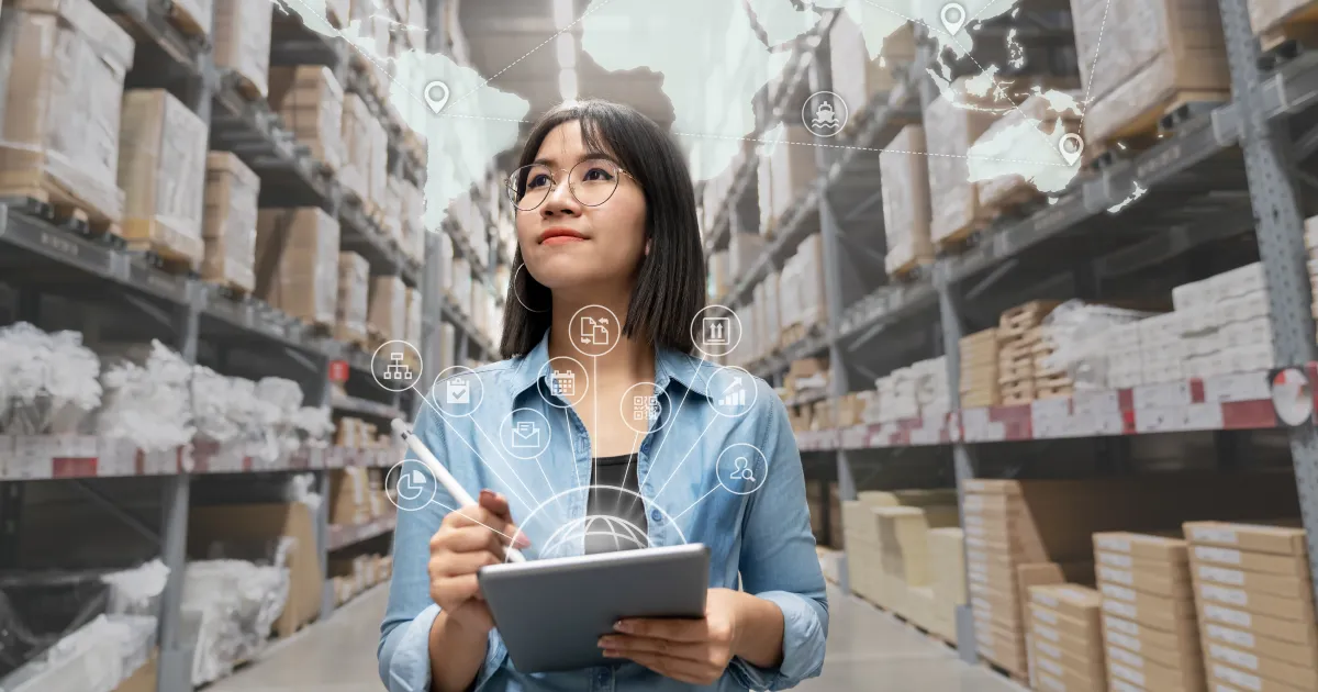 A woman walking through a warehouse with a tablet. Above her head is a graphic showing a map of a complex supply chain.